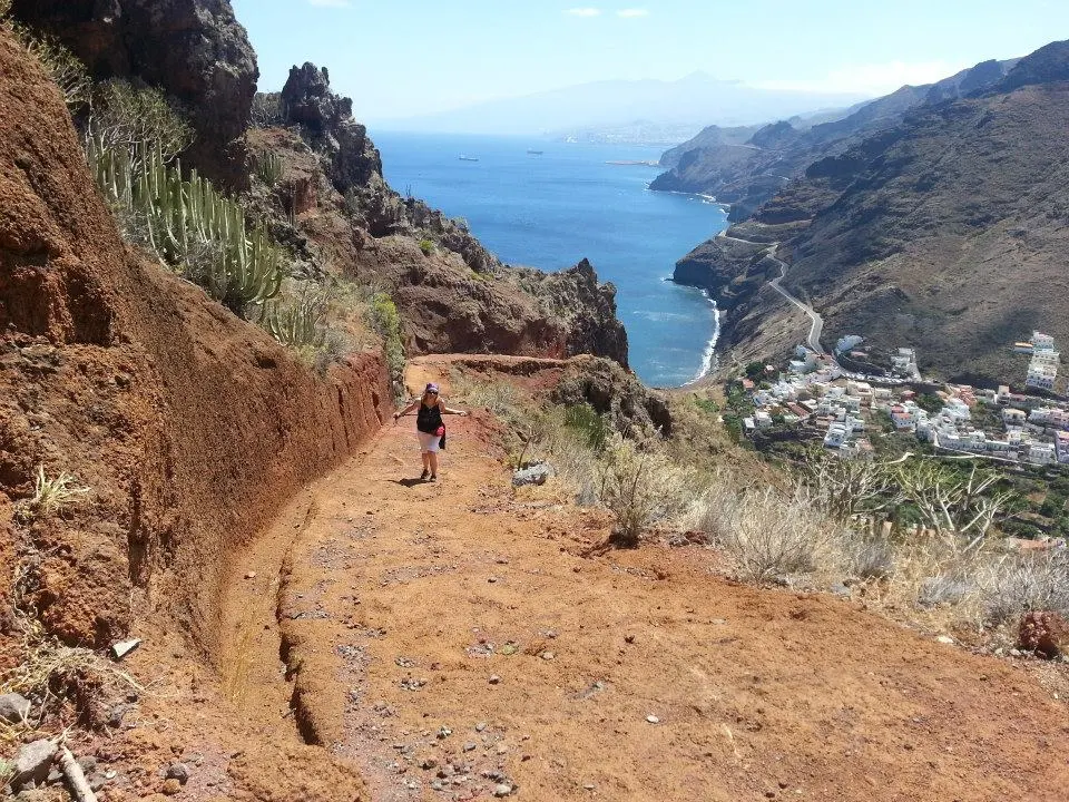 Georgia Mihalcea, writer of Canarian Dream, climbs a mountain path on the trail to the Semaphore of Anaga in Igueste de San Andrés, Tenerife, Canary Islands, Spain. This image represents the film's exploration of new beginnings and finding meaning beyond the traditional rat race by following Film Shaper Methodology of crafting a film digital blueprint.